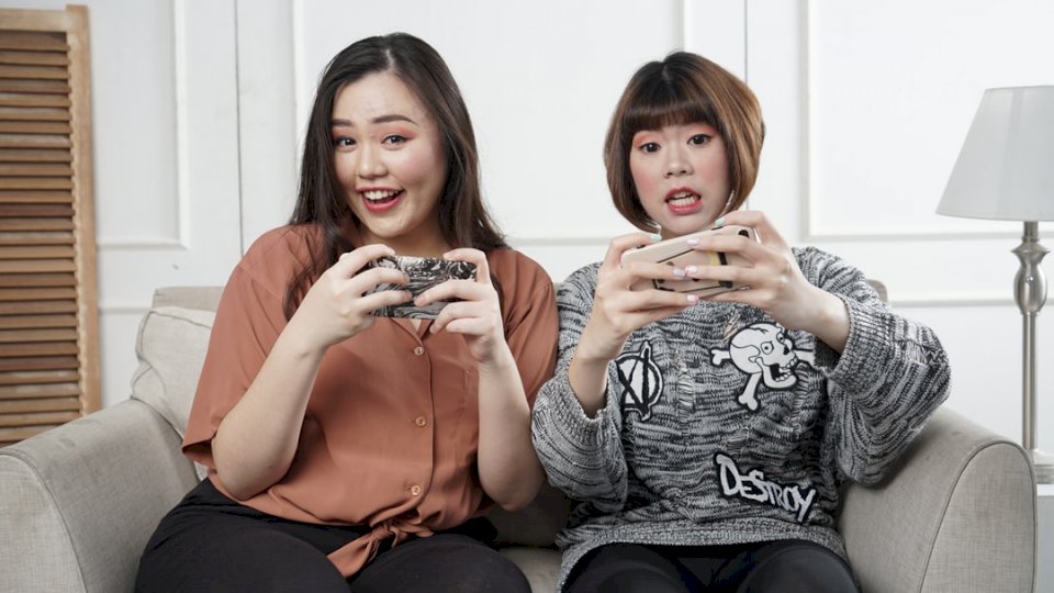 Azjatycka kobieta bawić się mobilną grę puzzle online