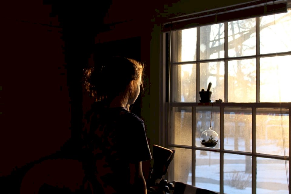 Kobieta wyglądająca przez okno puzzle online