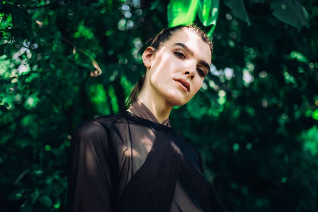 kobieta nosi czystą górę pod zielonymi liśćmi roślin puzzle online