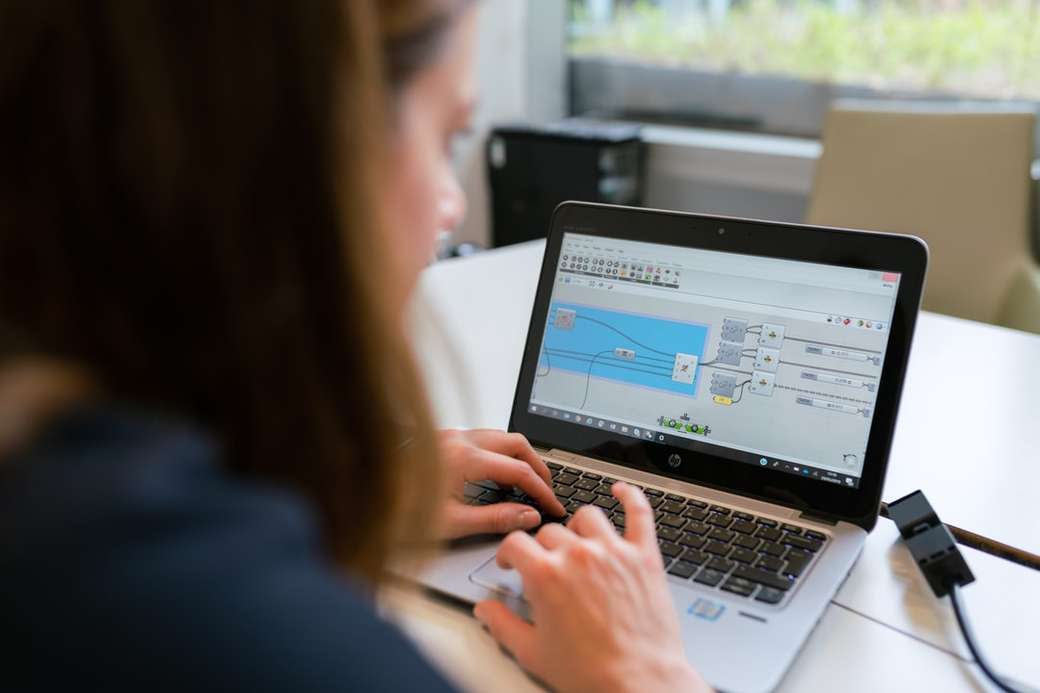 kobieta w czarnej koszuli z długim rękawem za pomocą MacBooka Pro puzzle online