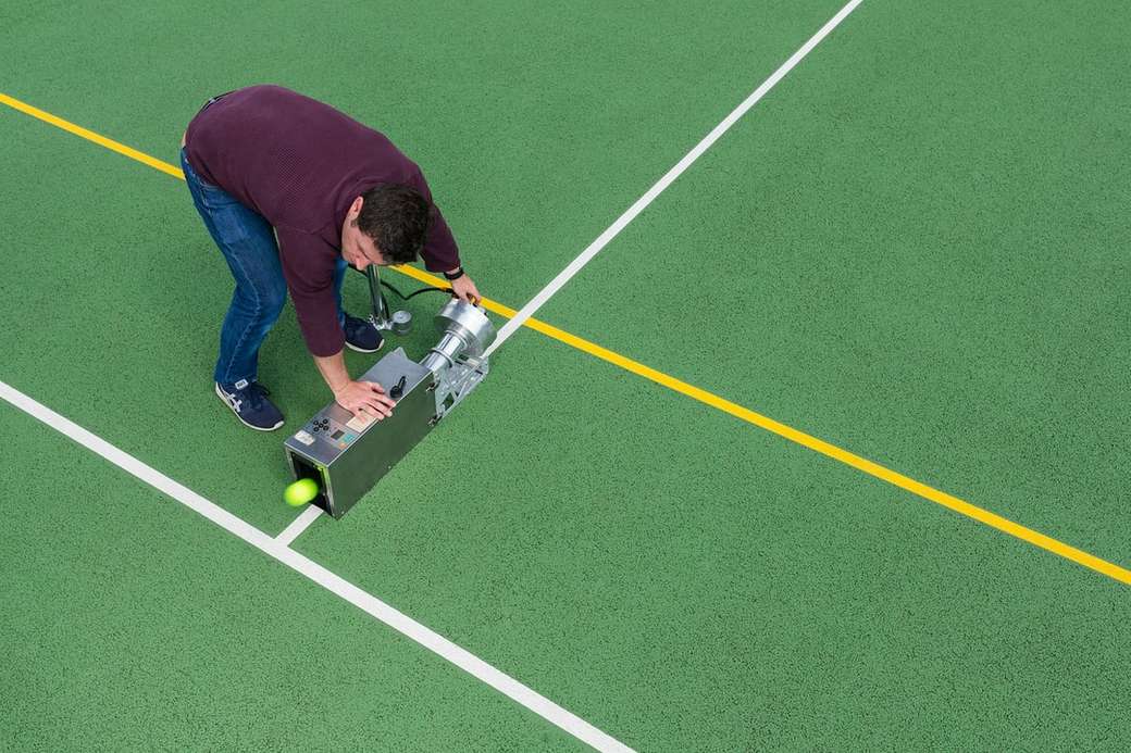 Męski inżynier sportowy testuje sprzęt do tenisa puzzle online