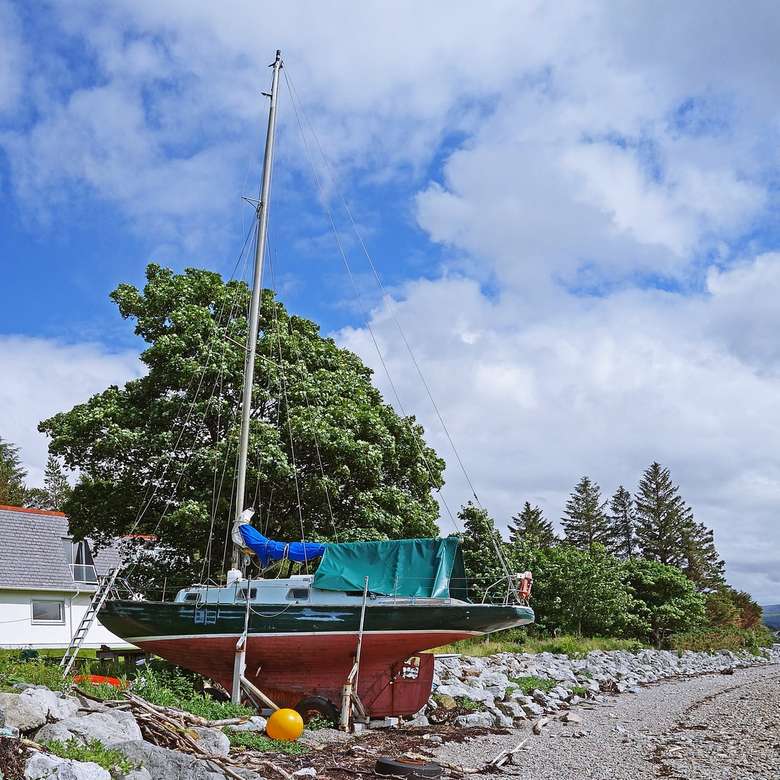 zielono-biała łódź na brzegu morza w ciągu dnia puzzle online
