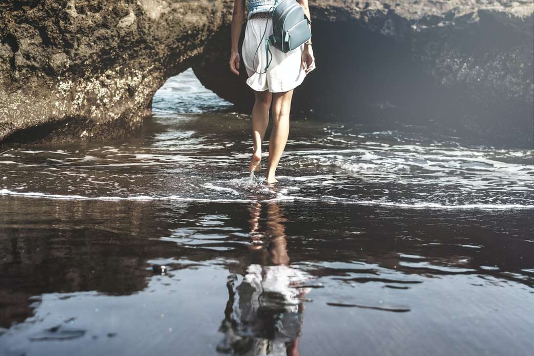 Młoda kobieta na plaży z czarnym piaskiem, wyspa Bali. puzzle online