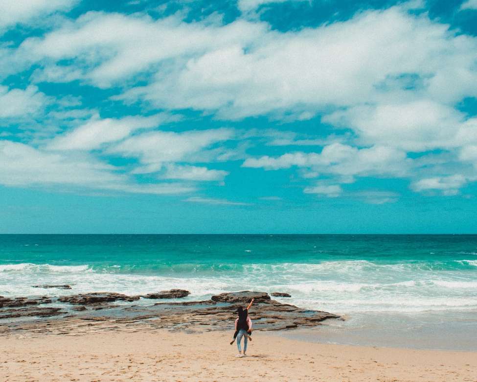 osoba niosąca inną osobę na plecach na plaży puzzle online