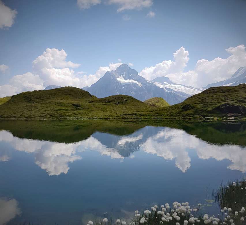 zielone i brązowe góry nad jeziorem pod błękitnym niebem puzzle online