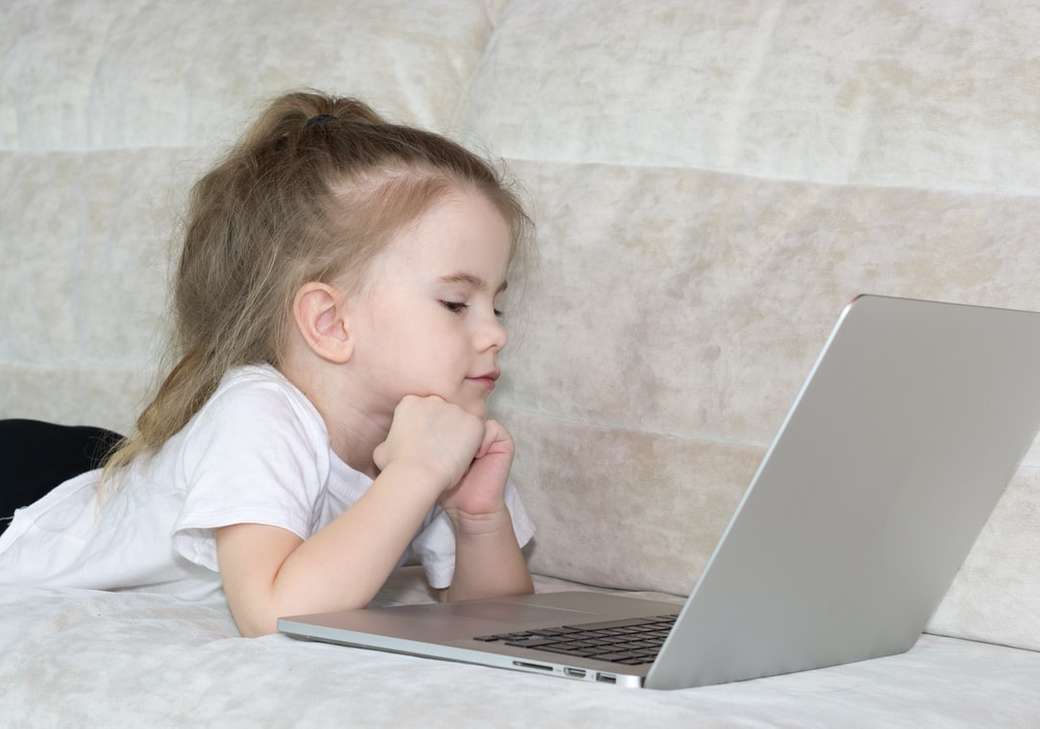 dziewczyna w białej koszulce za pomocą srebrnego laptopa puzzle online