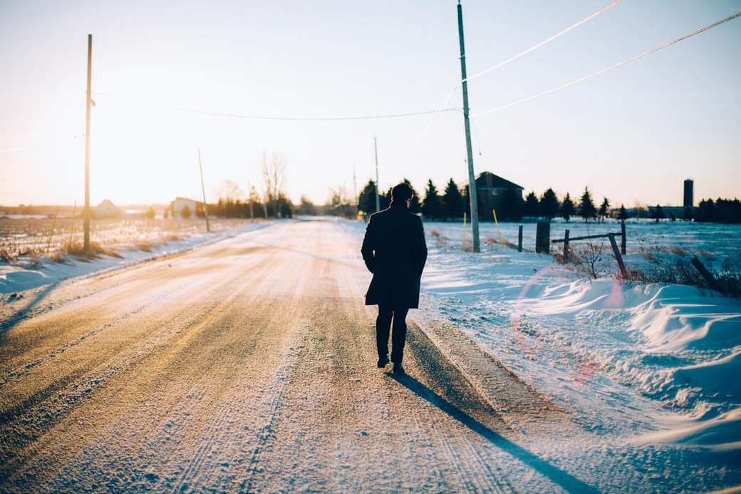 człowiek idący środkiem drogi pokrytej śniegiem puzzle online