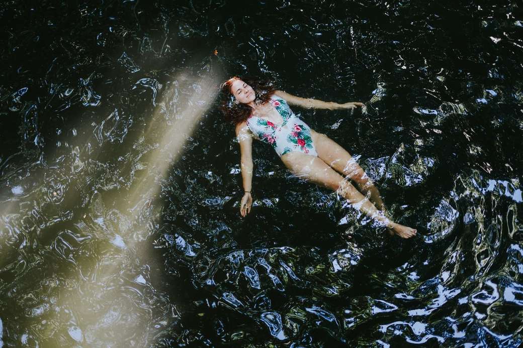 kobieta w bikini niebieski i biały kwiatowy leżący na wodzie puzzle online