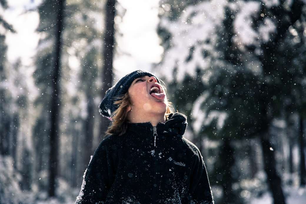 Dziewczyna wystaje język, żeby złapać płatki śniegu. puzzle online
