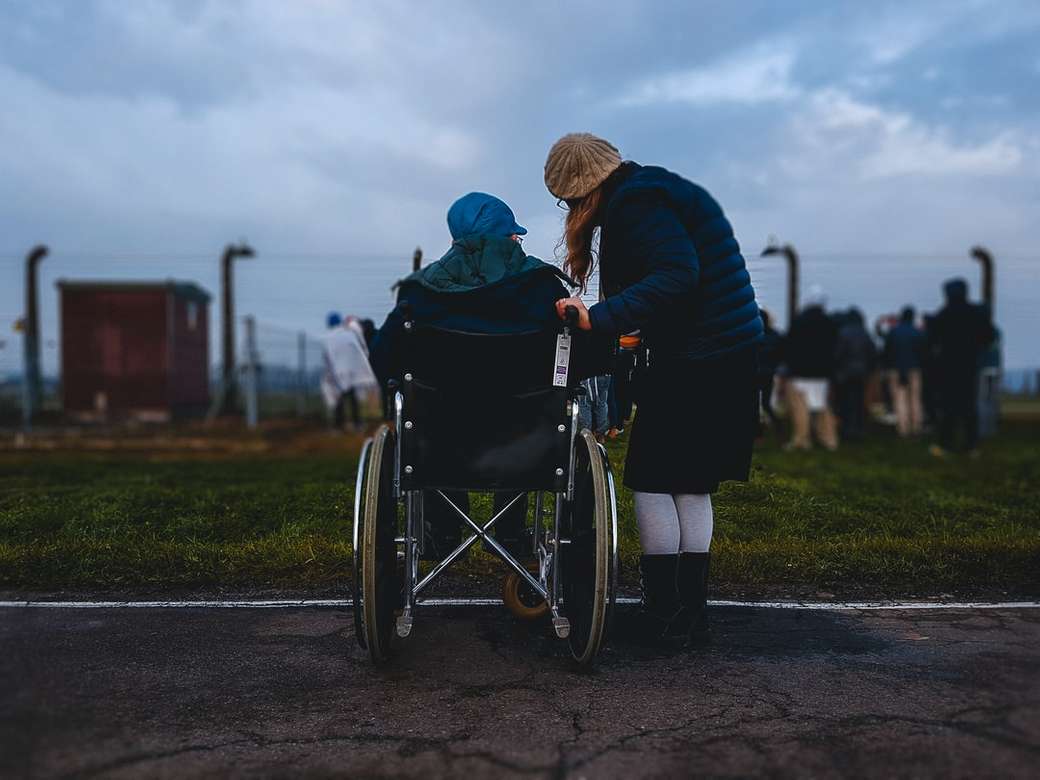 kobieta stojąca w pobliżu osoby na wózku inwalidzkim puzzle online