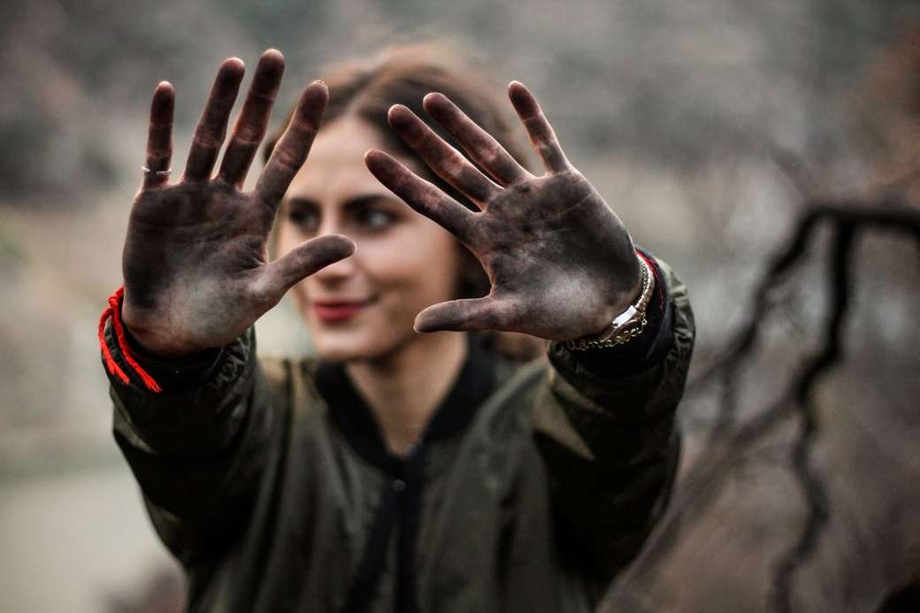 kobieta pokazuje ręce czarną farbą puzzle online