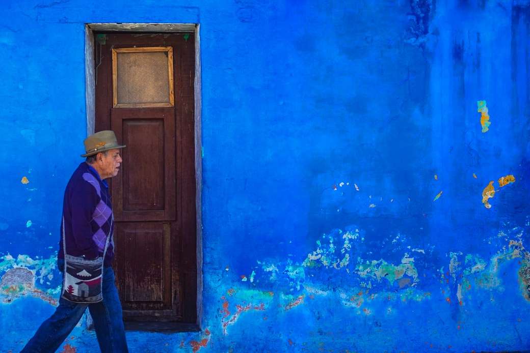 człowiek idący obok budynku pomalowanego na niebiesko puzzle online