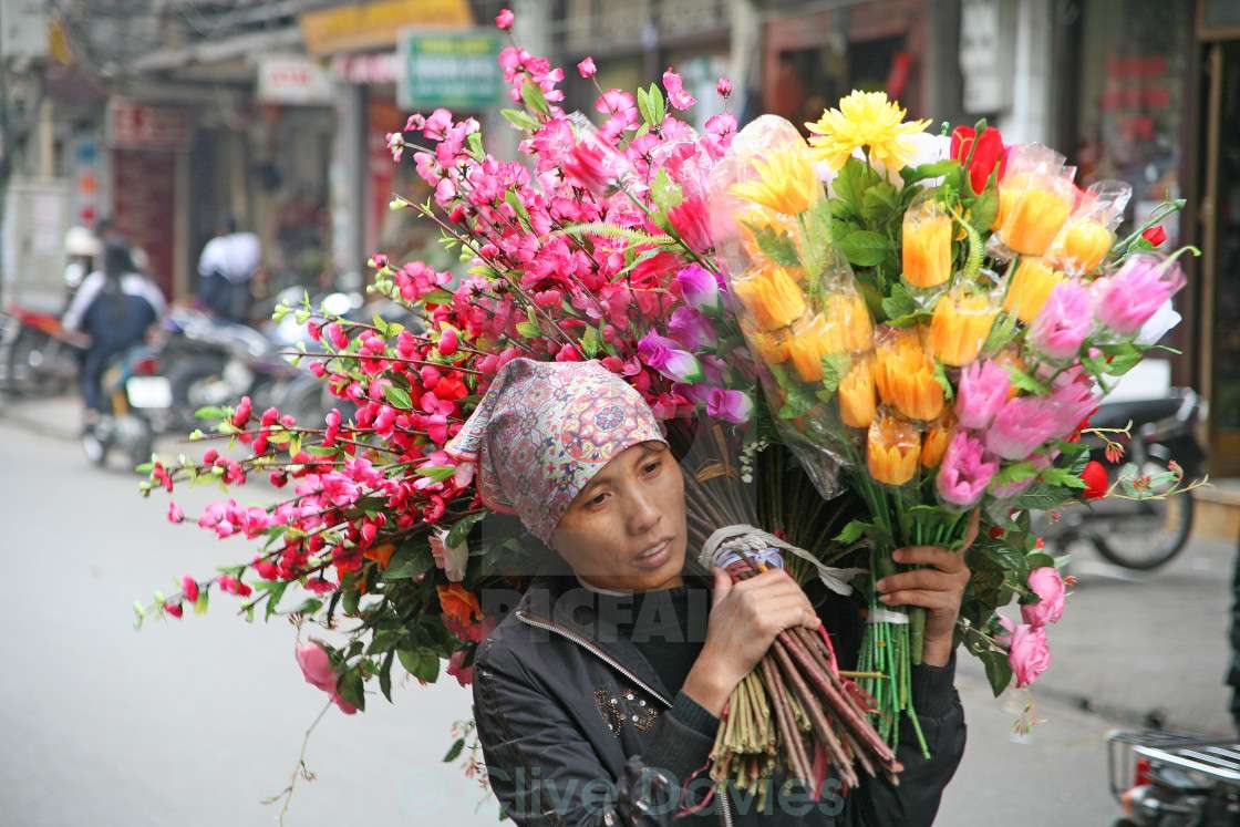 kobieta niosąca kwiaty na sprzedaż puzzle online