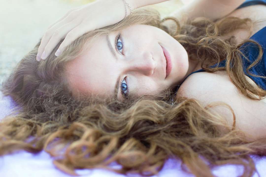 kobieta w fioletowym podkoszulku, leżąc na niebieskim materiale puzzle online