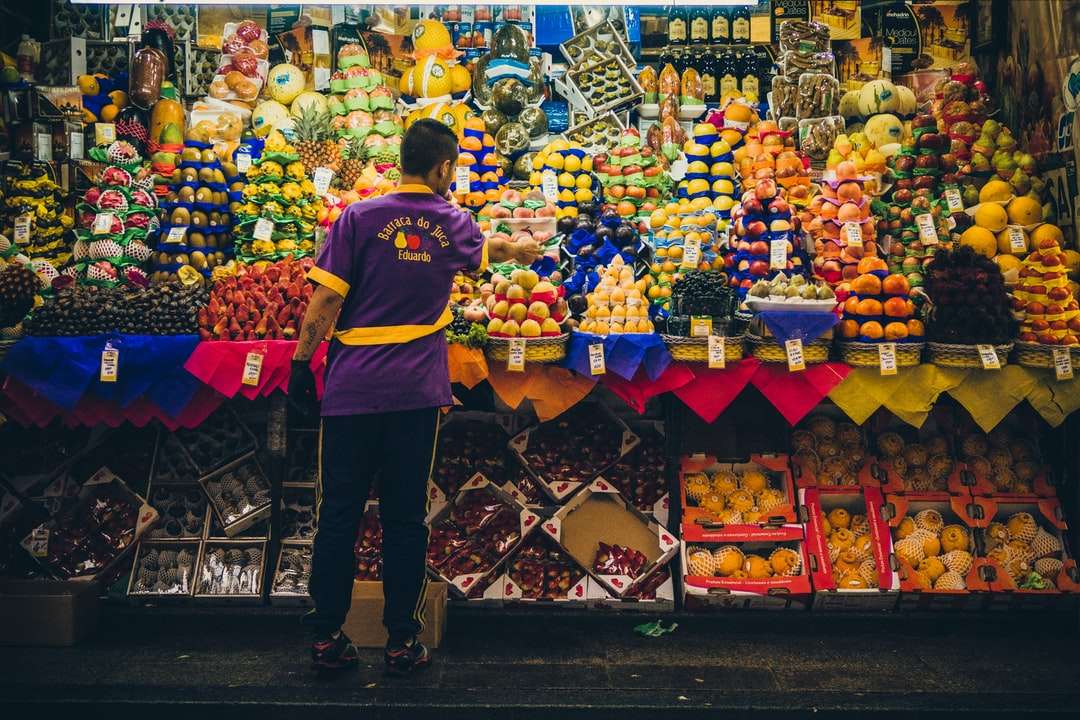 człowiek stojący przed stoiskiem z produktami puzzle online