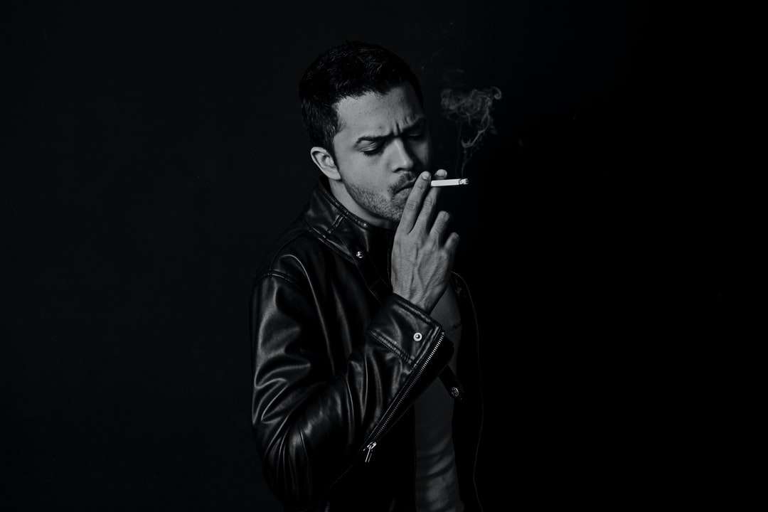zdjęcie w skali szarości człowieka palącego papierosa puzzle online
