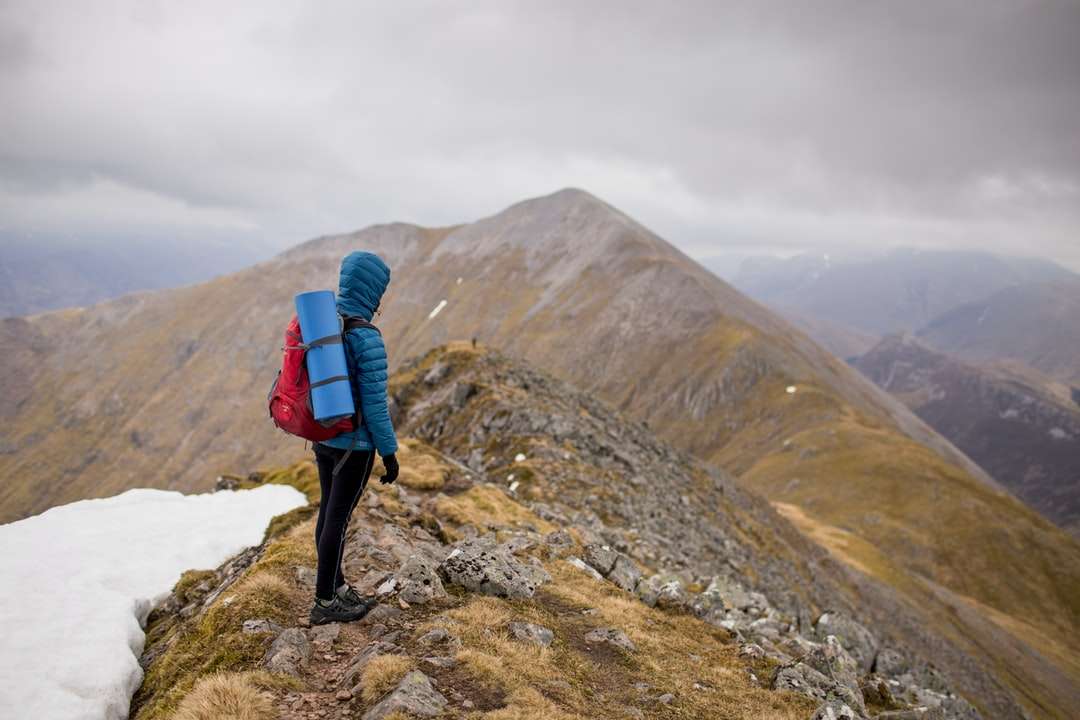osoba na szczycie góry niosąca czerwony plecak puzzle online