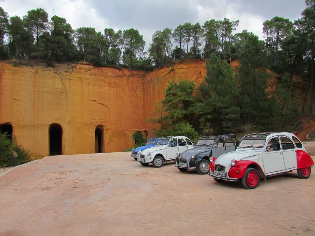 biało-czerwone samochody zaparkowane przy brązowej betonowej ścianie puzzle online