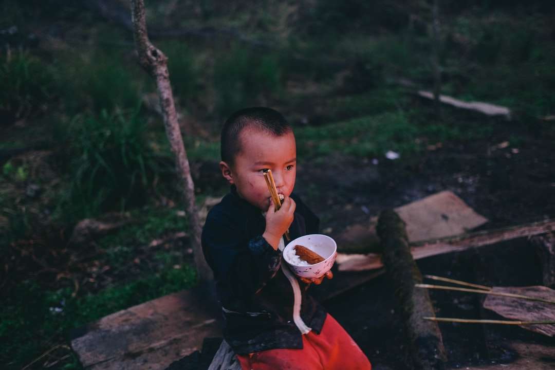 chłopiec kolczyk jedzenie trzymając okrągłą białą miskę z parą puzzle online