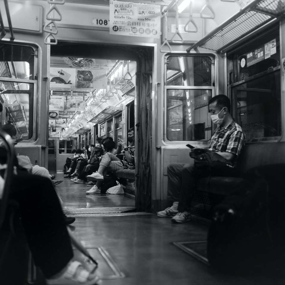 gråskalefoto av människor inne i tåget pussel