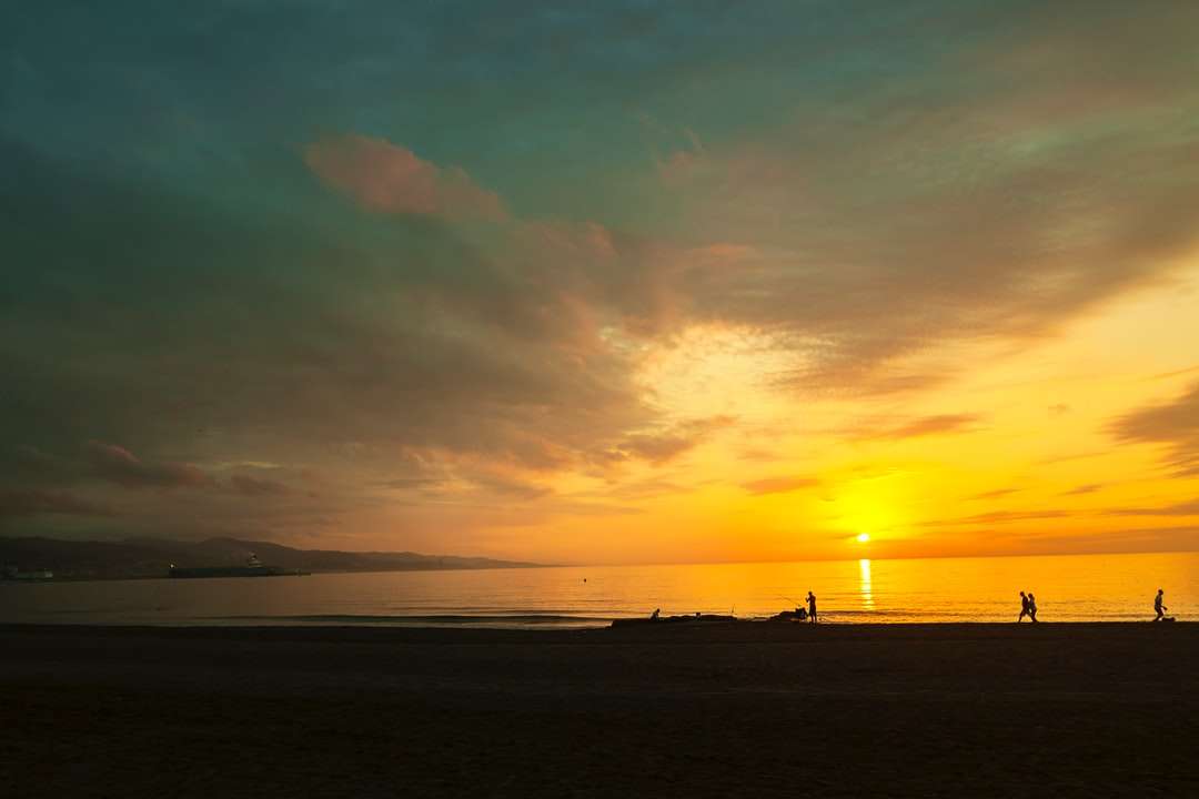 sylwetka ludzi na plaży podczas zachodu słońca puzzle online