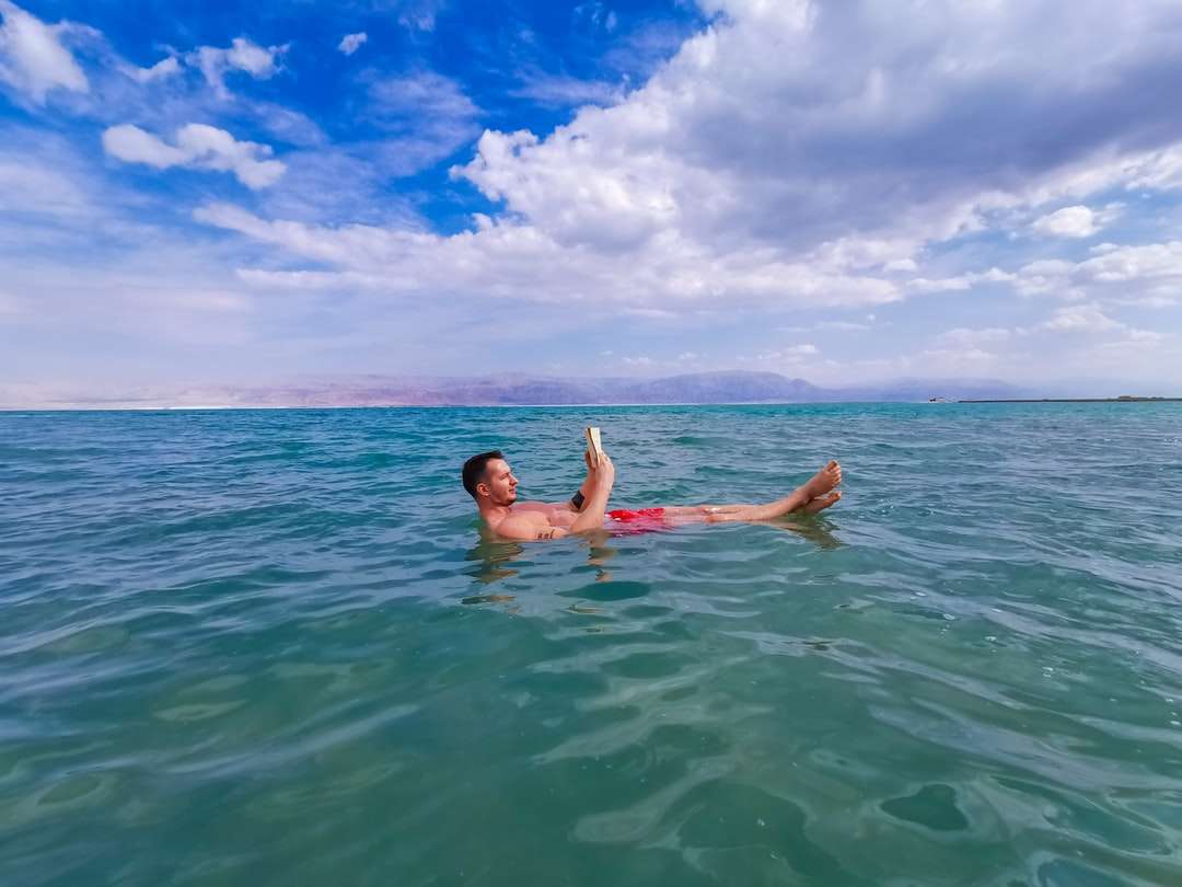 kobieta w niebieskim i białym bikini pływanie w morzu puzzle online
