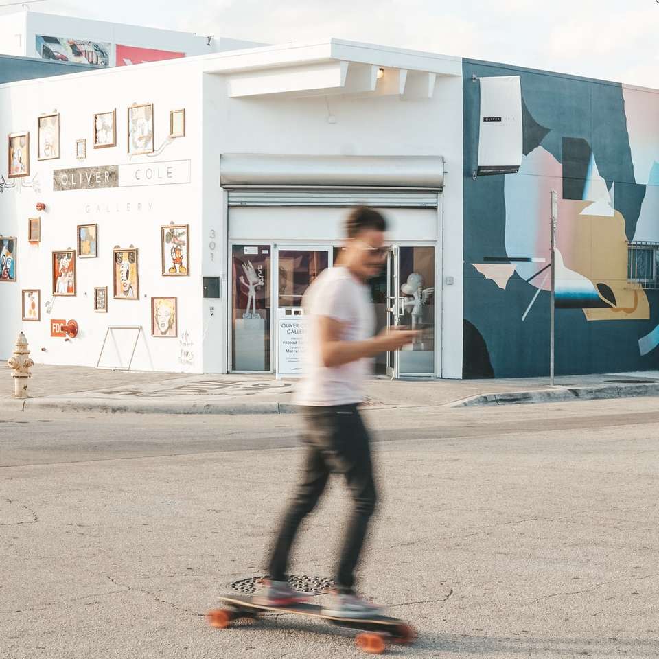 człowiek za pomocą longboardu w pobliżu struktury biały i turkusowy puzzle online