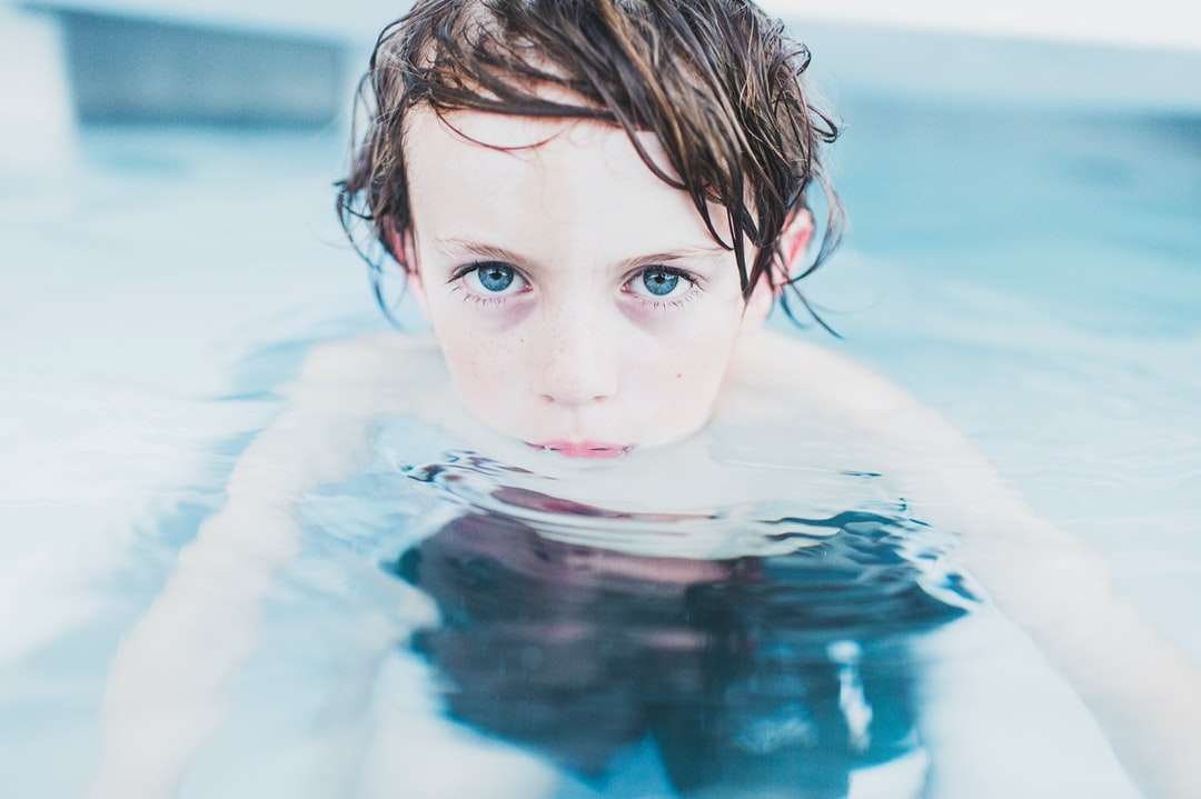 selektywna fotografia ostrości chłopca unoszący się na wodzie puzzle online