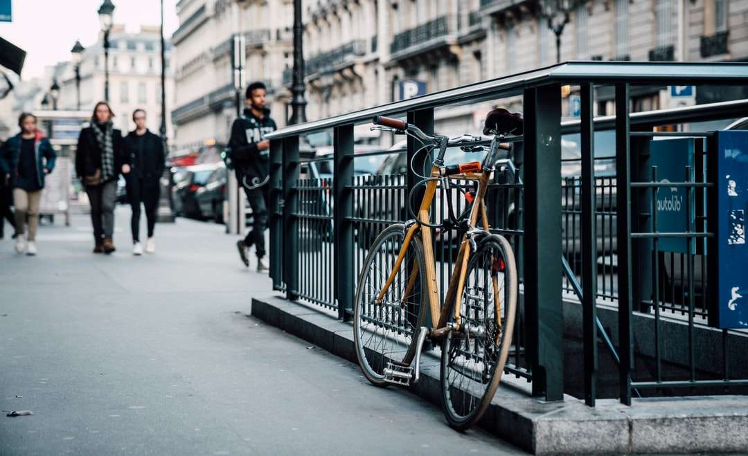 zaparkowany pomarańczowy rower na barierkach metra puzzle online