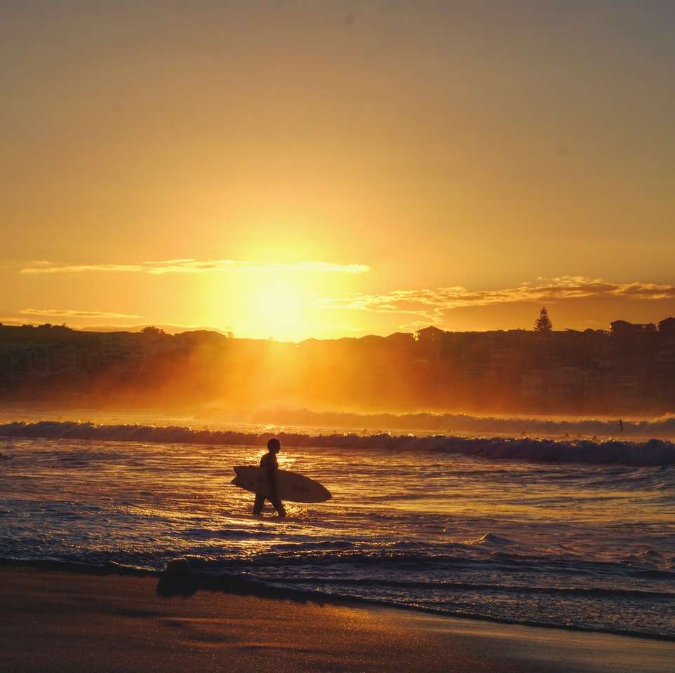 sylwetka człowieka stojącego na plaży podczas zachodu słońca puzzle online