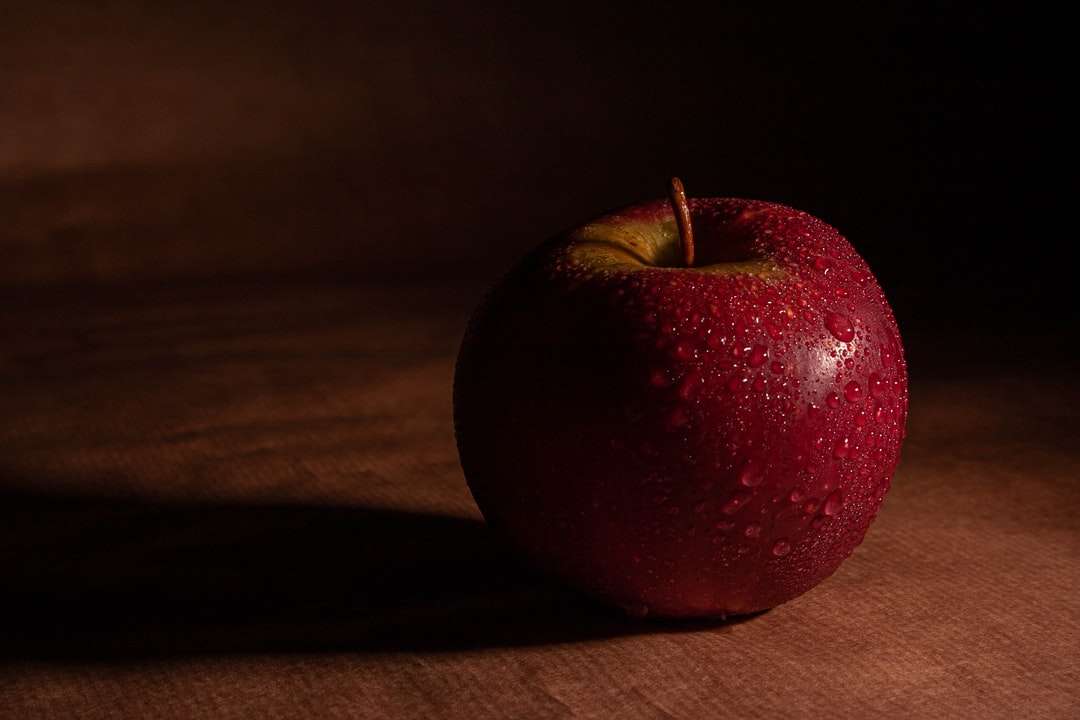 czerwone jabłko na brązowym drewnianym stole puzzle online