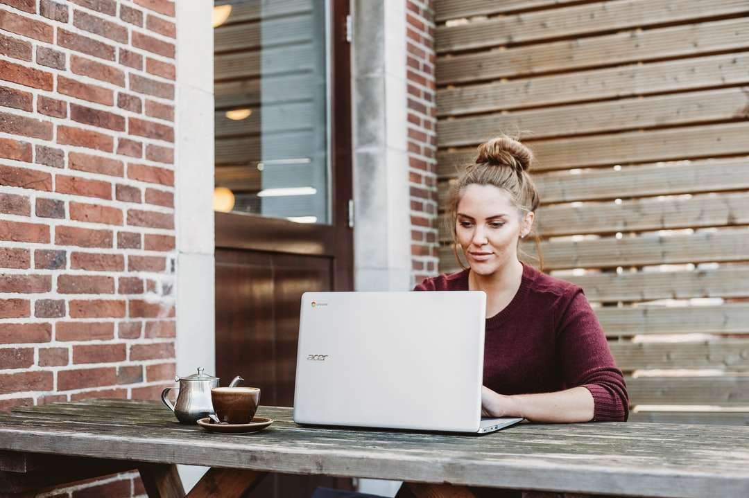 kobieta siedzi i trzyma biały laptop Acer puzzle online
