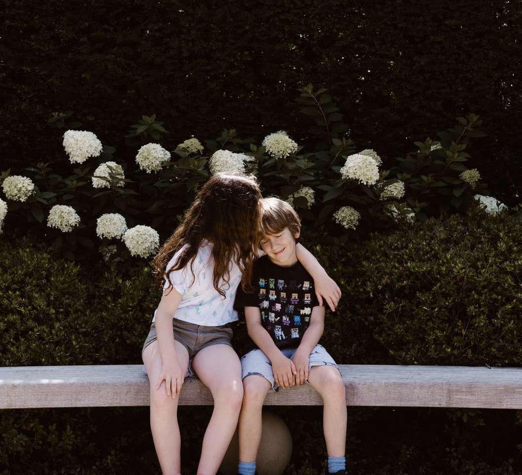dwie małe dziewczynki i chłopiec siedzący na betonowej ławce puzzle online