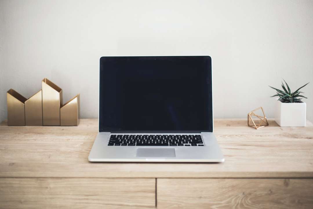 MacBook Pro na brązowym stole puzzle online