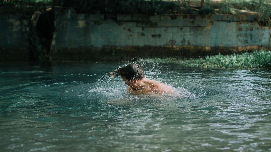 człowiek pływający po wodzie w ciągu dnia puzzle online