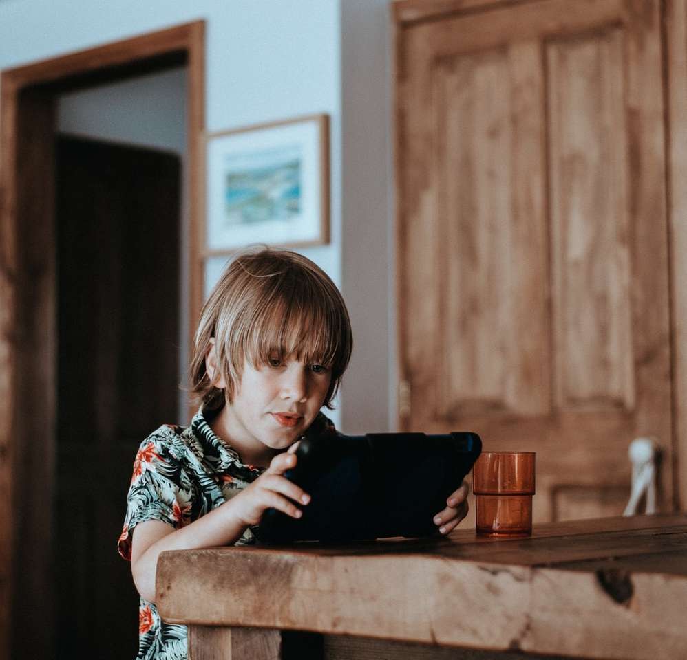 selektywne skupienie dziecka przy użyciu komputera typu tablet na stole puzzle online