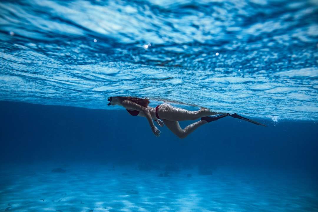 kobieta w czarnym bikini pływanie w wodzie puzzle online