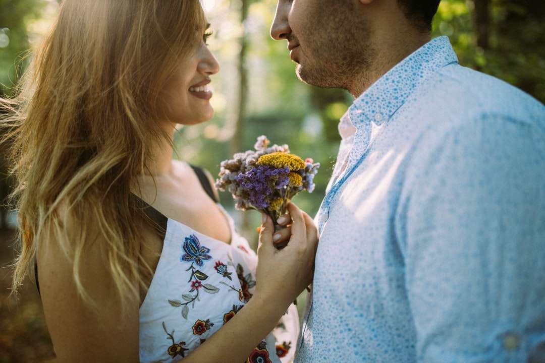 mężczyzna i kobieta, naprzeciw siebie, trzymając kwiaty puzzle online