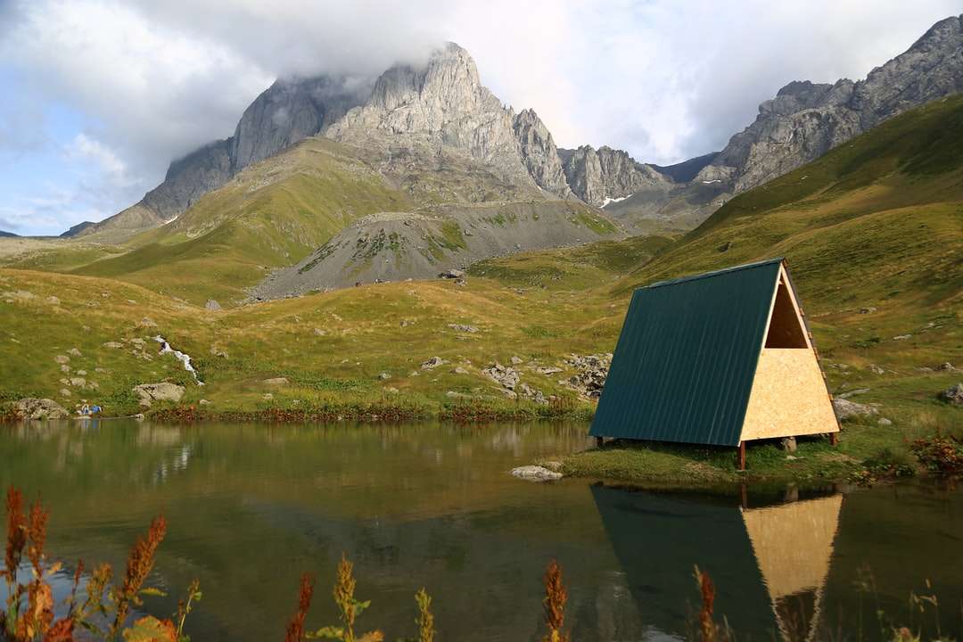 zielono-beżowa drewniana chata na zbiorniku wodnym puzzle online