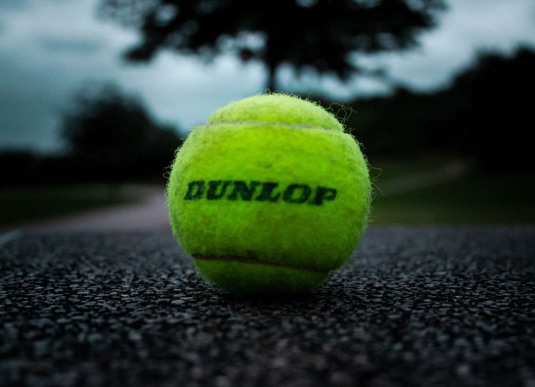 zielona piłka tenisowa na czarnej tkaninie puzzle online