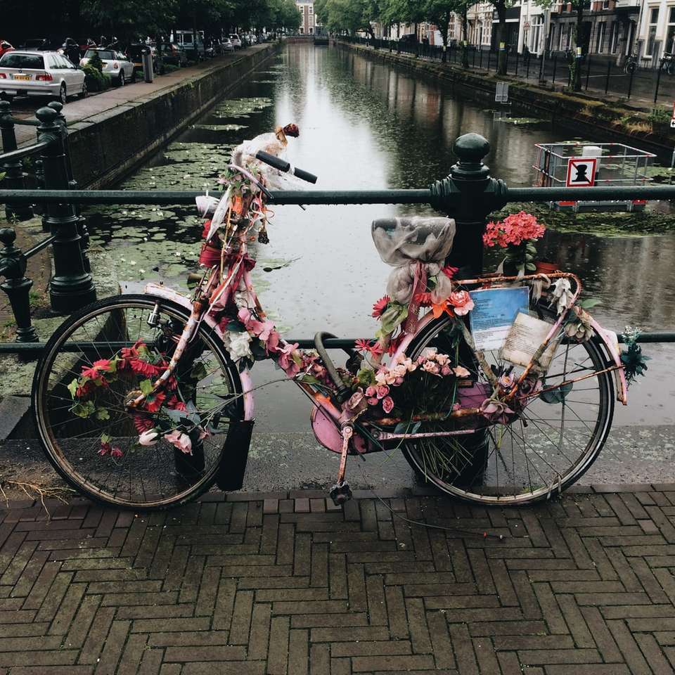 rower pokryty kwiatami na moście w pobliżu stawu puzzle online