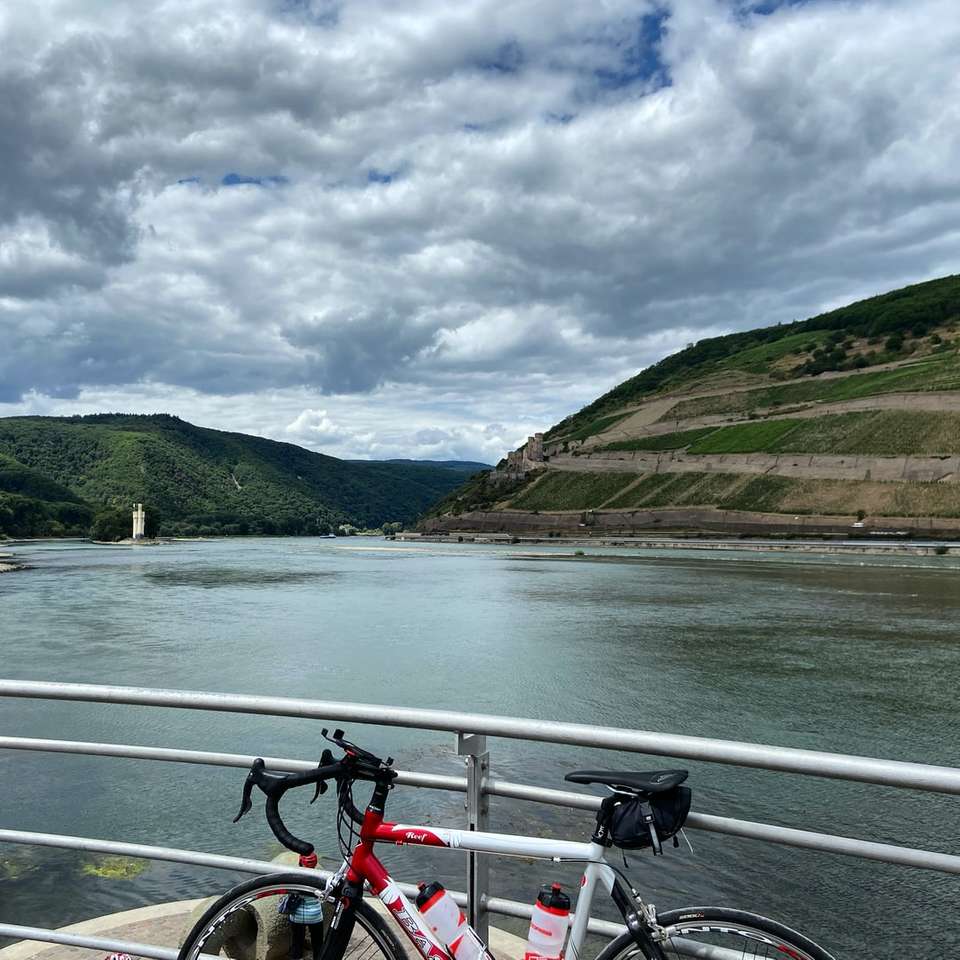 czerwony i biały rower na drodze w pobliżu zbiornika wodnego puzzle online