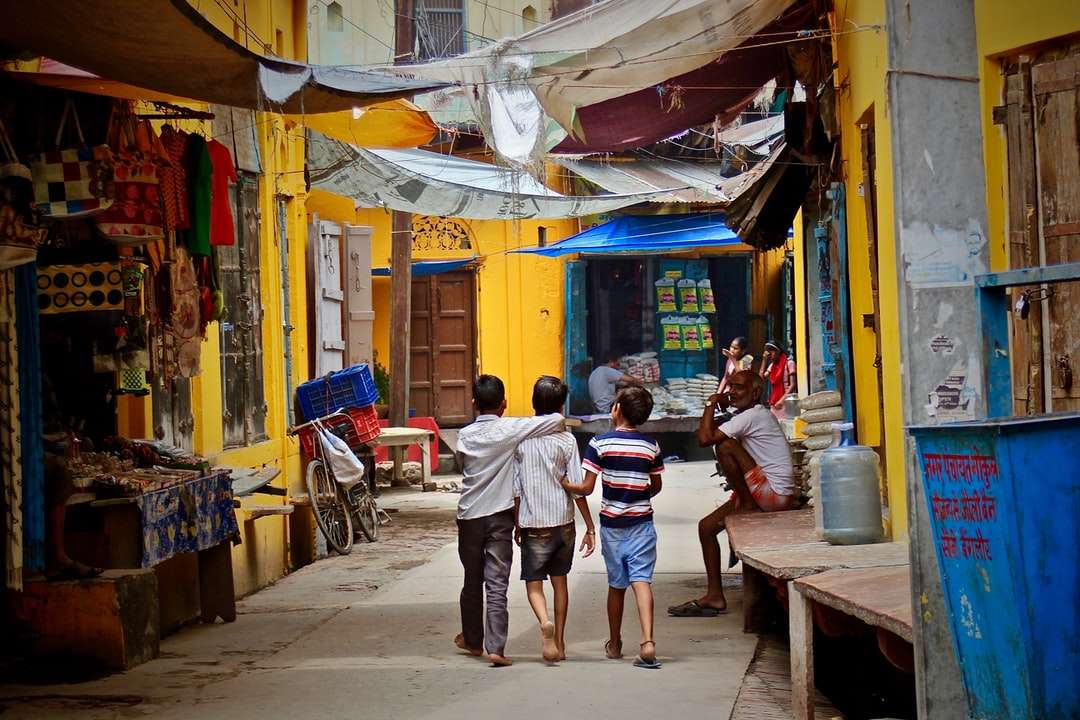 trzech chłopców spacerujących między budynkami w ciągu dnia puzzle online