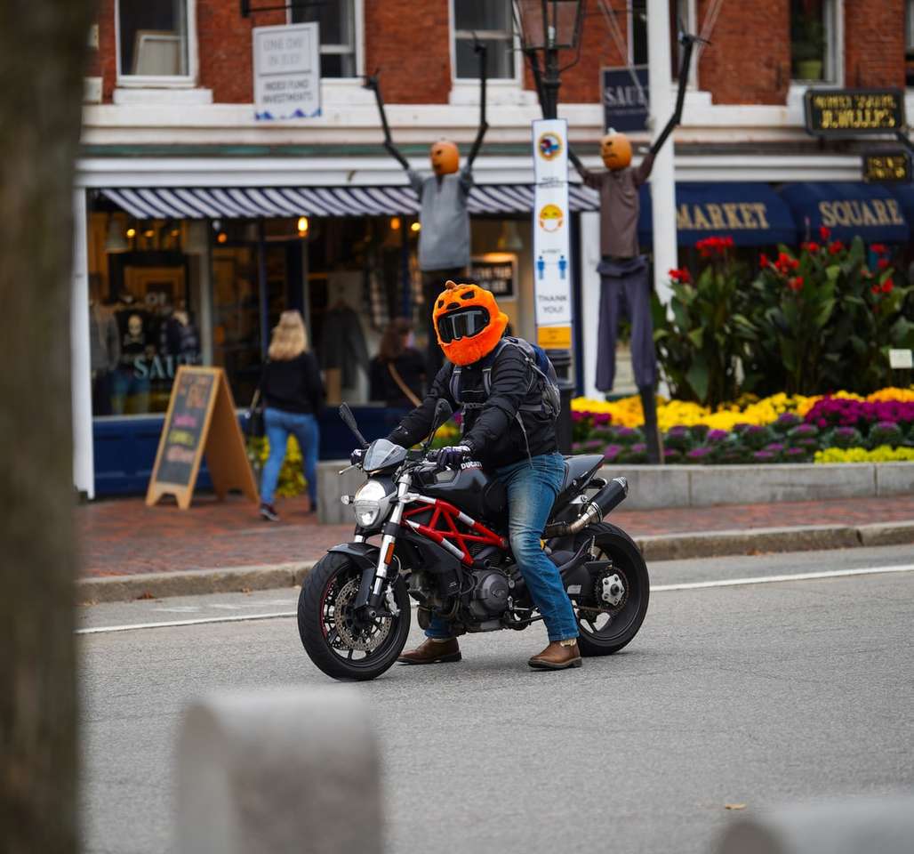 mężczyzna w pomarańczowym kasku, jazda na czarnym motocyklu na drodze puzzle online