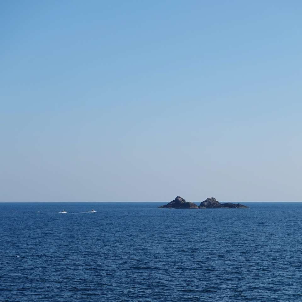 dwie łodzie na wodzie w pobliżu wysepki w ciągu dnia puzzle online