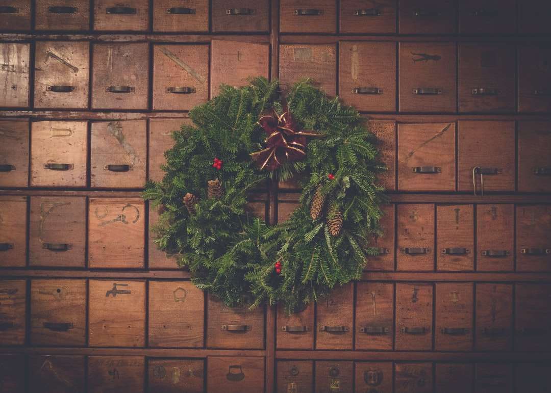 zielony i brązowy wieniec bożonarodzeniowy szyszka na drewnianych szufladach puzzle online