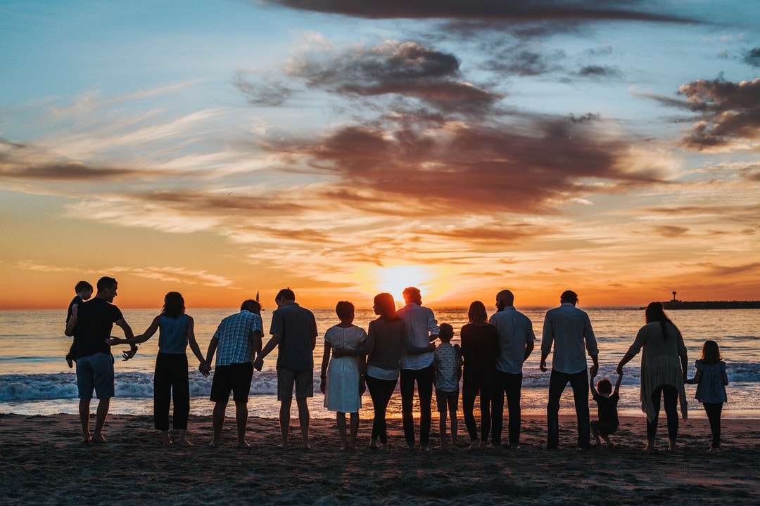 ludzie stojący na brzegu w czasie złotej godziny puzzle online