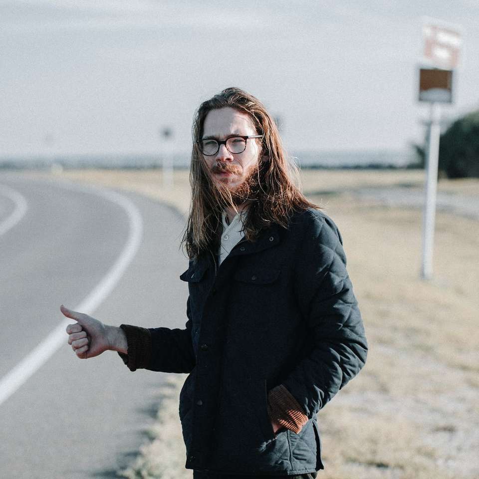 człowiek stojący w pobliżu drogi w ciągu dnia puzzle online