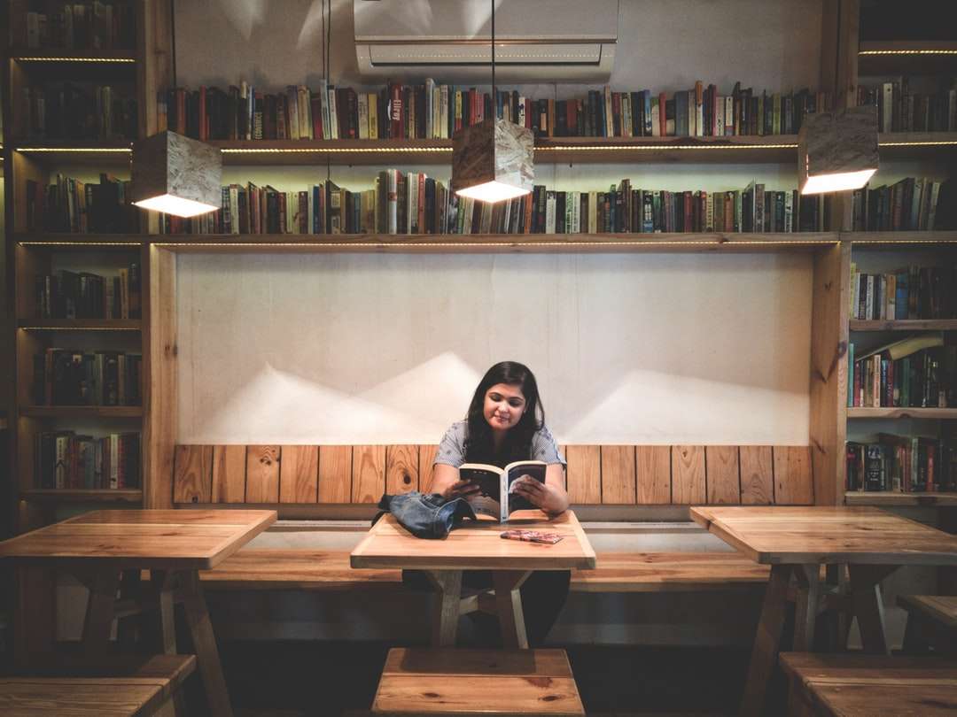 kobieta czytająca książkę wewnątrz biblioteki puzzle online