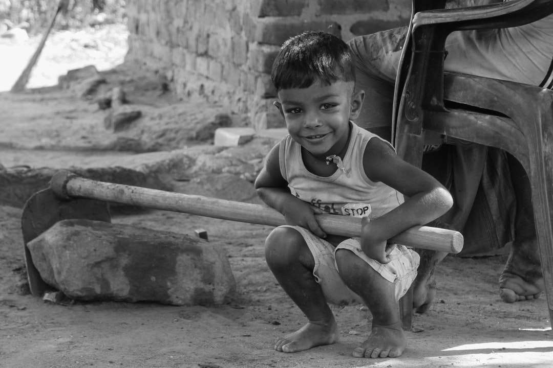 zdjęcie w skali szarości chłopca w podkoszulku, siedzącego na betonowej ścianie puzzle online